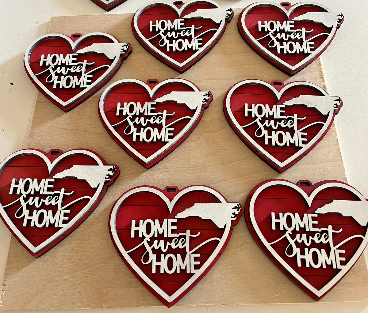 Heart-shaped 'Home Sweet Home' decorations on a wooden board.